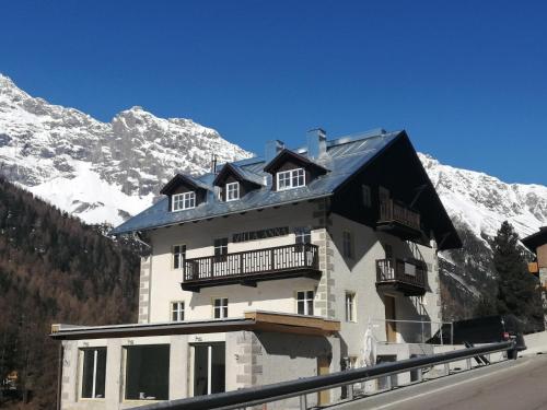 a building with a snow covered mountain in the background at Villa Anna in Solda