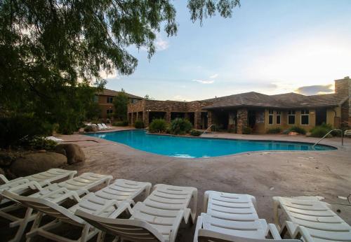 eine Gruppe weißer Liegestühle vor einem Pool in der Unterkunft B9 Zion National Park Rental Top Floor 2-bedroom Hillside View in Washington