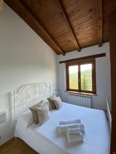 Un dormitorio con una cama blanca con una cruz. en Agriturismo Pettino, en Campello sul Clitunno