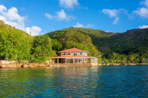 a house on a island in the middle of the water at La Saline in Praslin