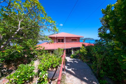 una casa con techo rojo en la playa en La Saline en Anse Possession