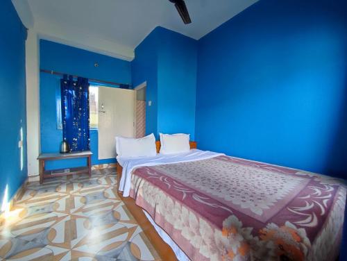 a blue bedroom with a bed and a blue wall at Tranquil Water Guest House in Pokhara