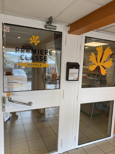 a front door of a store with a sign on it at Premiere Classe Lyon Sud - Chasse Sur Rhône in Chasse-sur-Rhône