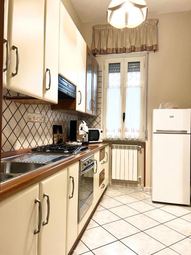 a kitchen with white cabinets and a white refrigerator at Royal House Trecase in Trecase