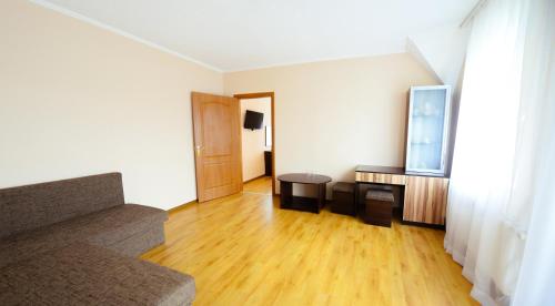 a living room with a couch and a television at Hotel Restaurant Vizit in Truskavets