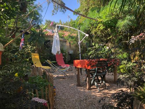 a garden with a table and chairs in a yard at L Atypique in LʼÎle-dʼOlonne