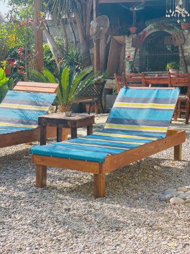 two wooden benches with blue cushions sitting on the ground at House of Sunset - Tranquility - View - Relaxation in Sívas