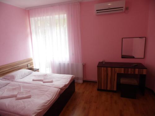 a bedroom with a bed and a table and a window at Hotel Restaurant Vizit in Truskavets