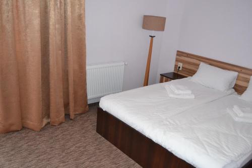a bedroom with a large bed with white sheets at Hotel Restaurant Vizit in Truskavets