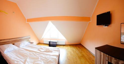 an orange room with a bed and a tv at Hotel Restaurant Vizit in Truskavets