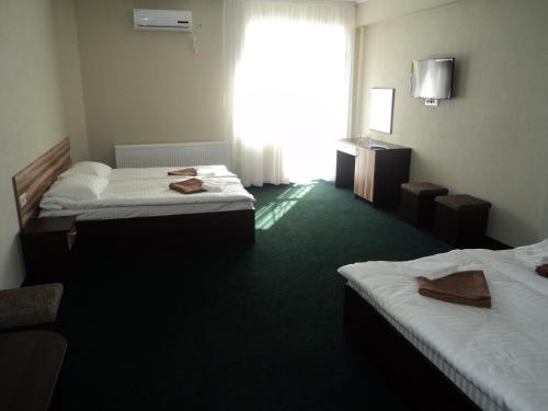 a hotel room with two beds and a window at Hotel Restaurant Vizit in Truskavets