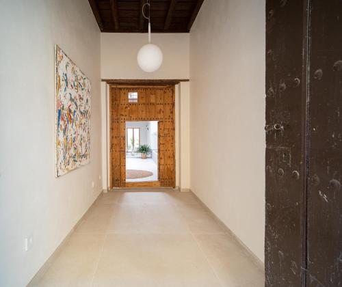 サンルーカル・デ・バラメダにあるApartamentos Alcoba 13の木製のドアと部屋が空の廊下