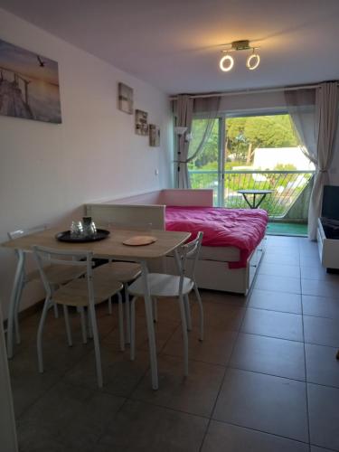 - une chambre avec une table, un lit, une table et des chaises dans l'établissement Les Appartements De Lina - Studio West City - Self Check-In, à La Grande Motte