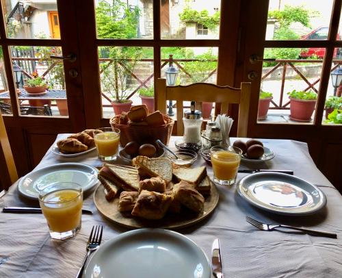 una mesa con platos de comida y vasos de zumo de naranja en Apostolos Hotel en Metsovo