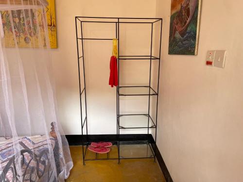 una habitación con un estante con una camisa roja. en Livingstone Legacy Lodge, en Arusha