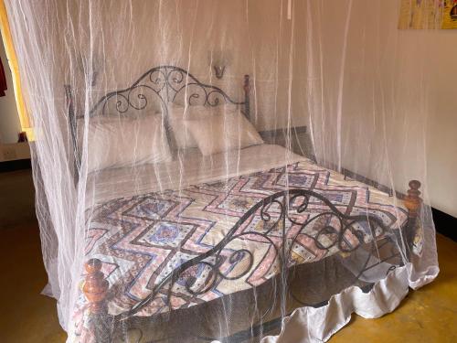 a bed covered in plastic with a quilt and pillows at Livingstone Legacy Lodge in Arusha