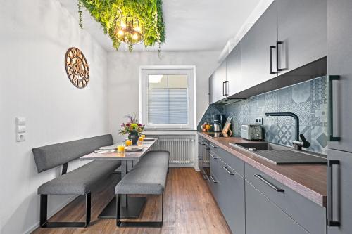 cocina con mesa, sillas y fregadero en Villa Dana Bodensee en Friedrichshafen