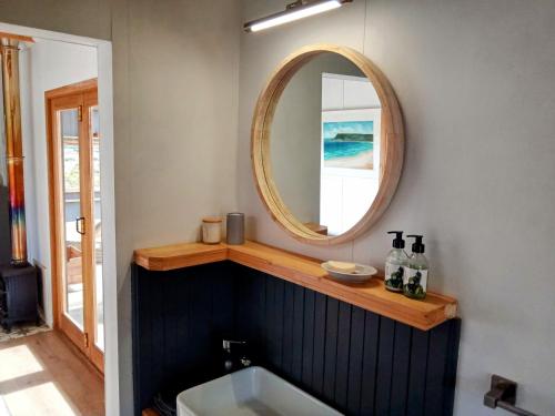 a bathroom with a sink and a mirror on a wall at Slow Track Farm in Baardskeerdersbos