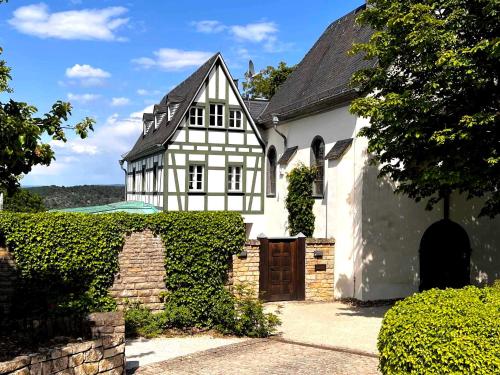 a white and black house with a gate at Altes Forsthaus Boppard in Boppard