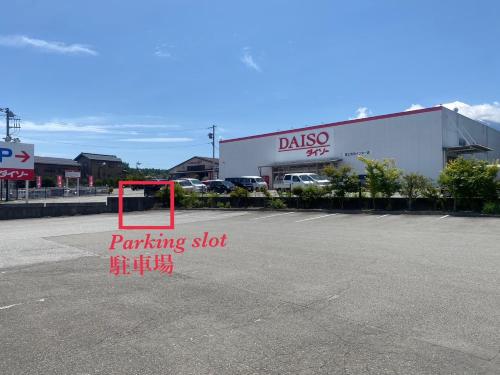 a parking lot with a parking sign in front of a building at 富士吉田たまきや in Fujiyoshida
