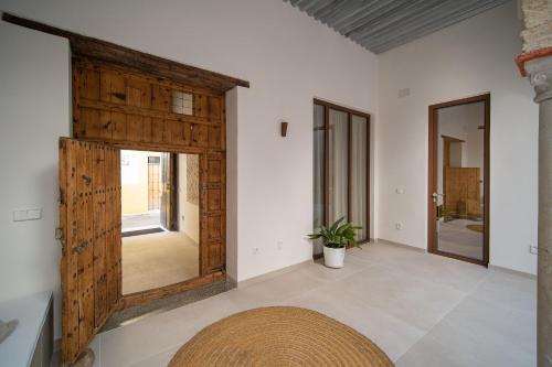 a room with a large wooden door and white walls at Apartamentos Alcoba 13 in Sanlúcar de Barrameda