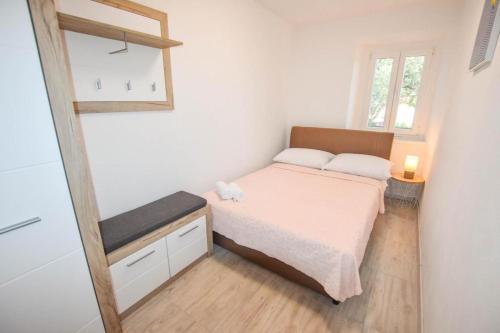 a small bedroom with a bed and a mirror at Suite Apartment Toni in Poljana