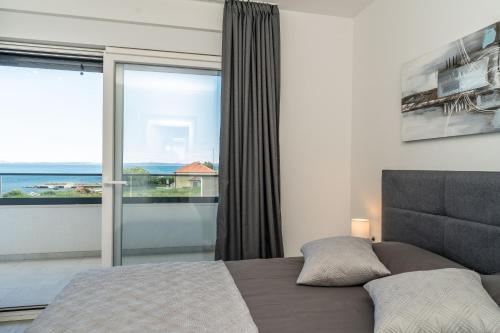 a bedroom with a bed and a large window at Kuća za odmor Marita in Privlaka
