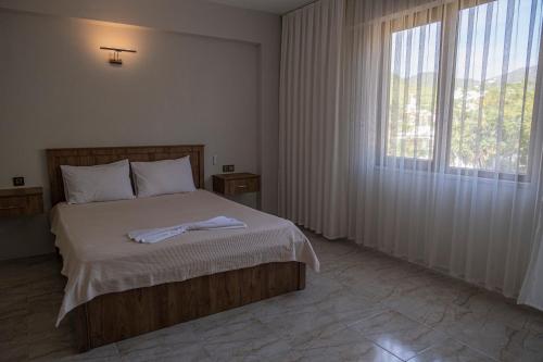 ein Schlafzimmer mit einem Bett und einem großen Fenster in der Unterkunft Olive Tree Apart Hotel in Muğla