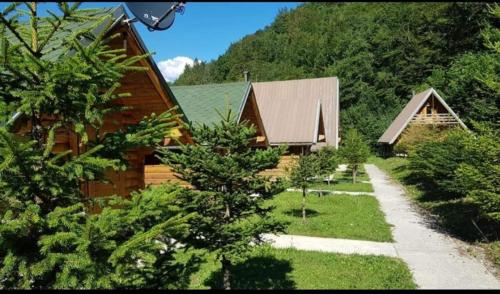 a group of houses with trees and a pathway at Villa Restaurant Mulliri in Peje