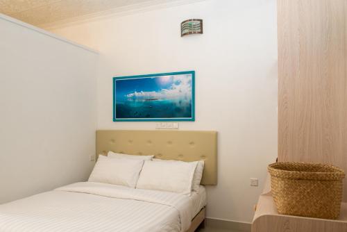 1 dormitorio con 1 cama y una foto en la pared en Rushkokaa Beach Villa, en Fulidhoo