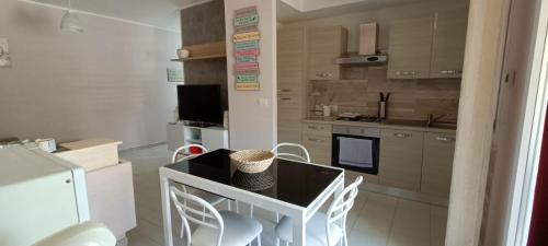 uma cozinha com mesa e cadeiras num quarto em Casa del Mare em Alghero
