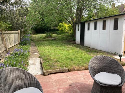 two chairs sitting on a patio in a backyard at Peaceful Home in Surbiton, Surrey, Greater London- Free parking in Surbiton