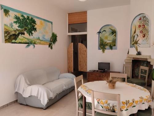 un soggiorno con divano e tavolo di Villa d'Arte a Maruggio