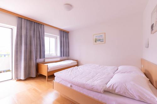 um quarto com uma cama grande e uma janela em Appartment Isabelle em Presseggersee
