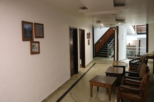 - un couloir avec des chaises, une table et des escaliers dans l'établissement The Abhinandan, à Mussoorie