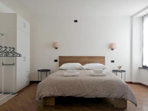 een slaapkamer met een groot bed en 2 handdoeken bij Golden Lake in Como