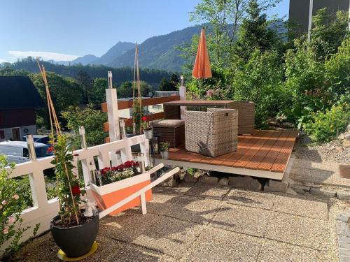 eine Terrasse mit einer Bank und einem Sonnenschirm in der Unterkunft Ferienwohnung Drachennest mit Sonnenterrasse in Feldkirch