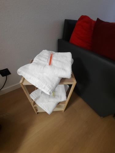 una pila de toallas en una mesa junto a un sofá en la casita de salou, en Salou