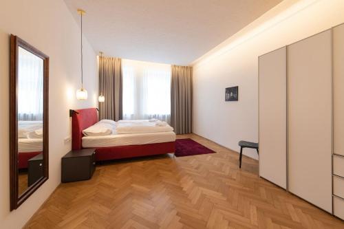 una camera da letto con un letto e uno specchio di Meranosuites a Merano