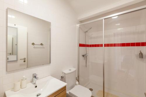 a bathroom with a white toilet and a glass shower at Sky Accommodations Studio in Coimbra