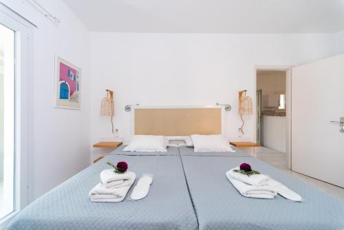 1 dormitorio con 1 cama con toallas en Averto Corfu Apartments, en Dassia