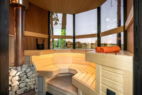 een lege kamer met houten vloeren en ramen bij SHANTI FOREST HOUSE Guest house with mirror sauna 