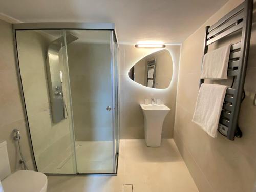 y baño con ducha y lavamanos. en Malvazia Residence en Kamilari