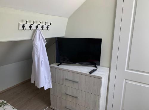 een woonkamer met een tv en een dressoir met een dressoir bij Un sommeil paisible in Brussel