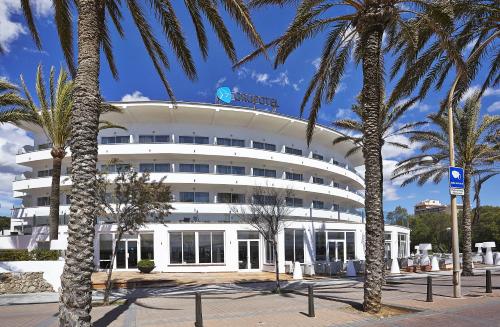 a white building with palm trees in front of it at Grupotel Acapulco Playa - Adults Only in Playa de Palma