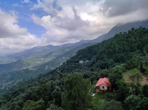a small house on top of a hill with mountains at Stunning Views, Jujurana Homestay Shoghi ! 3 Apartments Near Simla in Shogi
