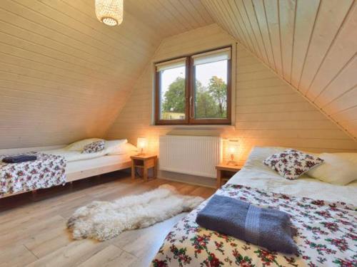 ヴィスワにあるGórska Pasja Wisłaのベッド2台と窓が備わる屋根裏部屋です。