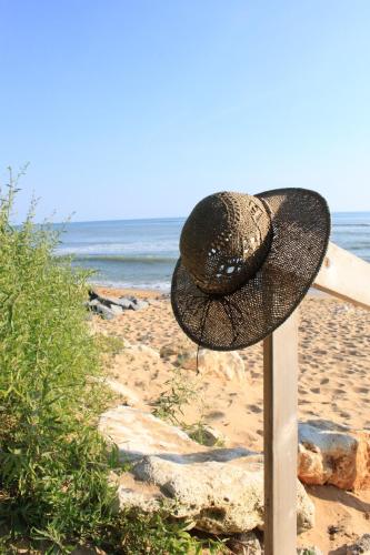a hat sitting on a pole on the beach at Face aux Flots in La Cotinière