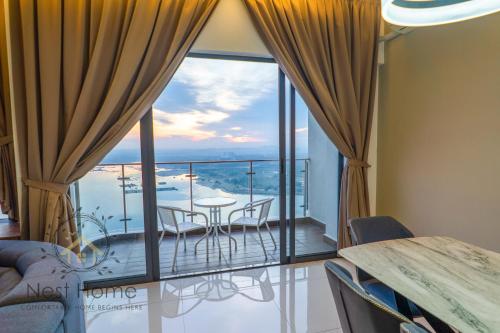 a room with a balcony with a table and chairs at Country Garden Seaview Suite by Nest Home at Danga Bay in Johor Bahru