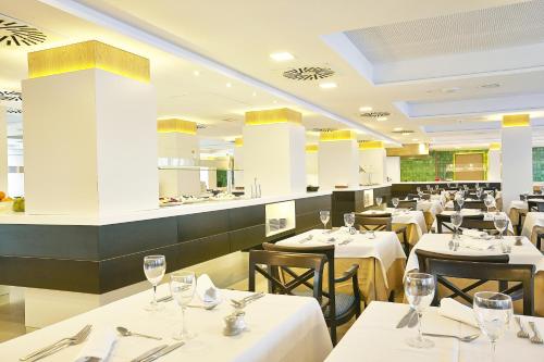 a restaurant with white tables and chairs with glasses on them at Grupotel Acapulco Playa - Adults Only in Playa de Palma